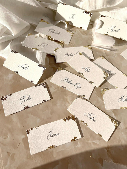 Handgemachte Hochzeit Namenskarten aus Büttenpapier mit Blattgold auf Marmor-Untergrund