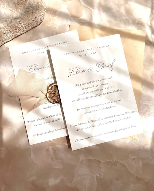Elegante Hochzeitseinladung aus Büttenpapier mit Siegel, Schleife und edlem Druck, auf Marmor