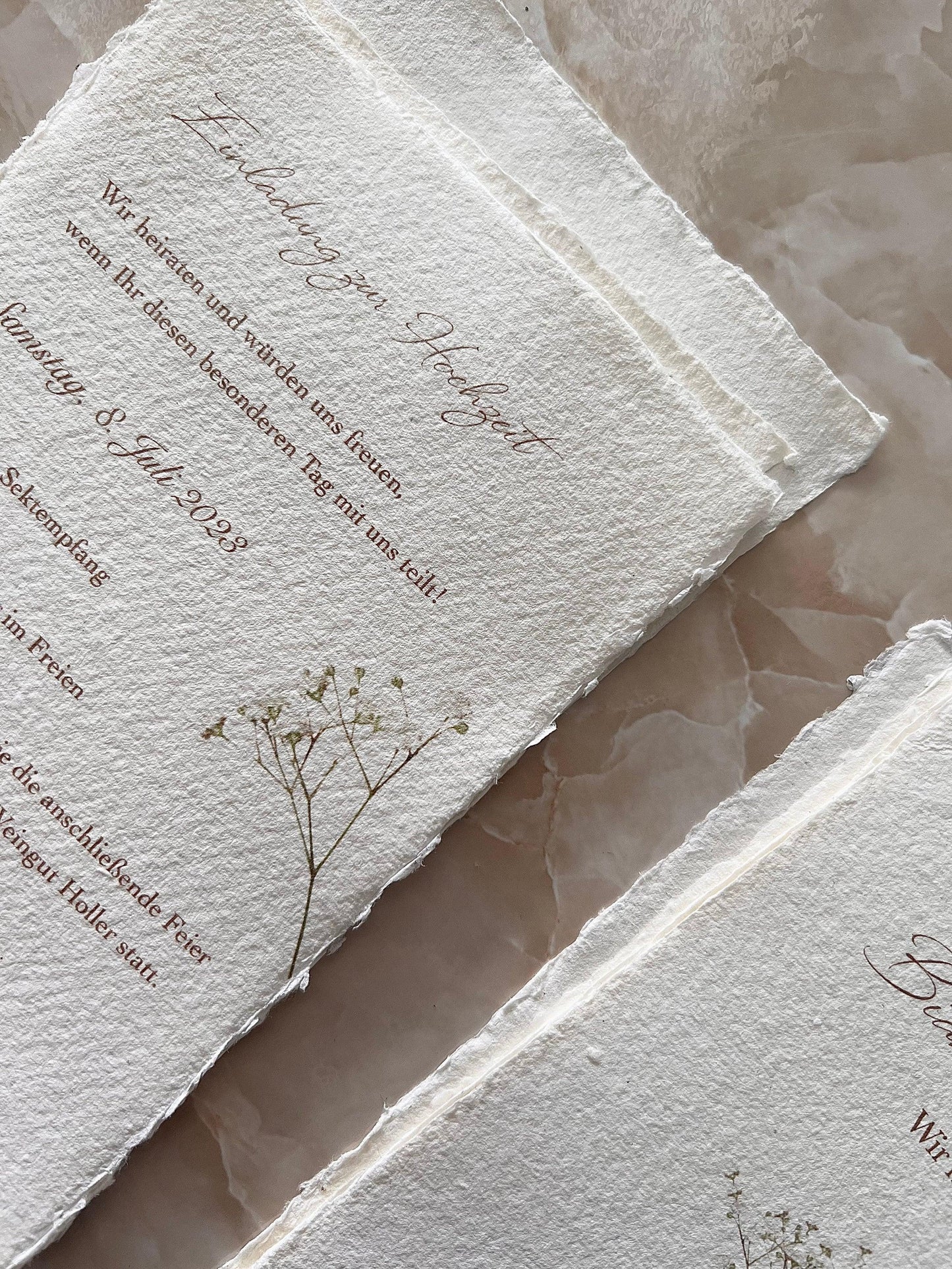 Handgemachte Hochzeitseinladung auf Büttenpapier mit zartem Blütendruck