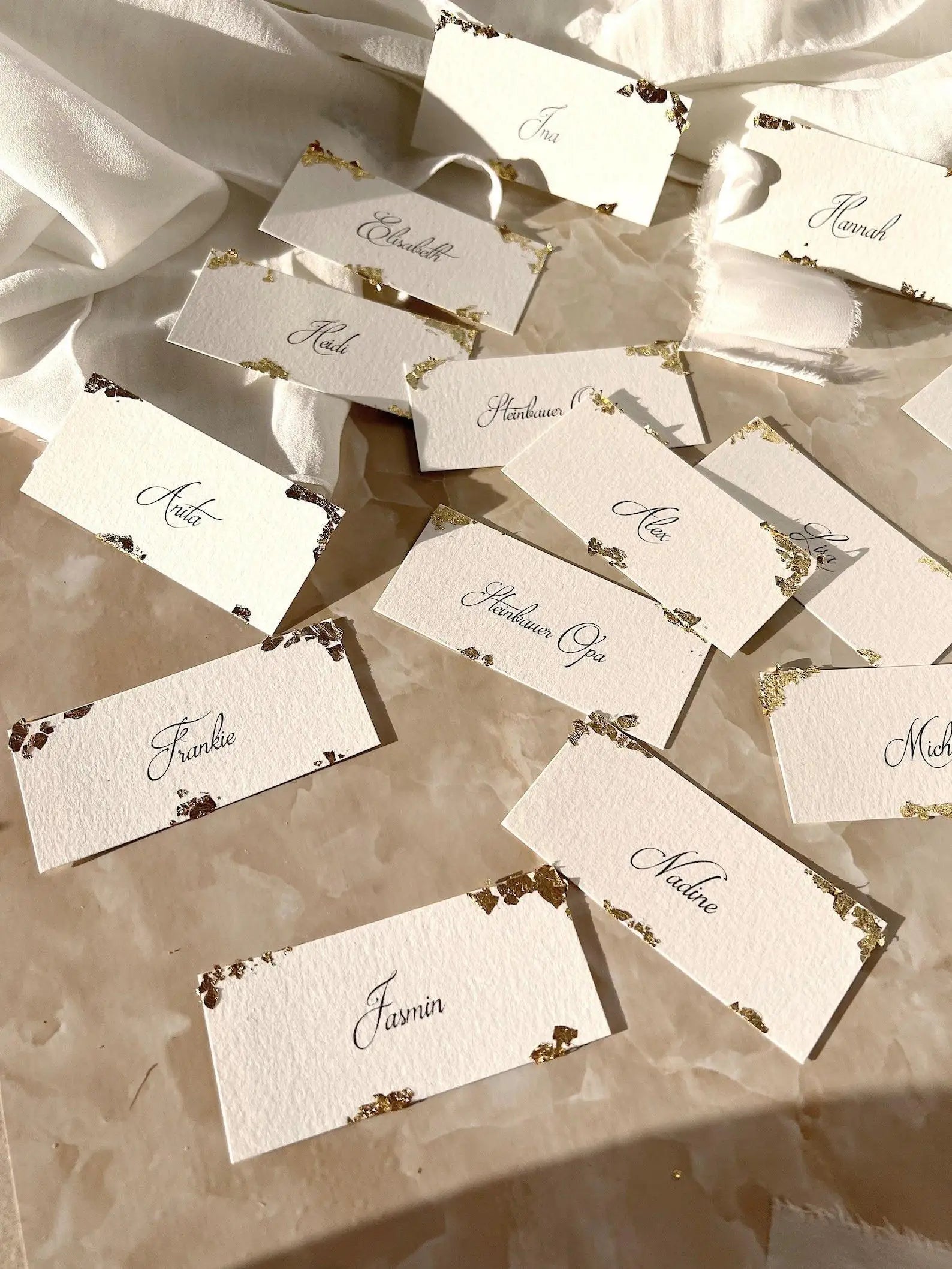 Handgemachte Hochzeit Namenskarten aus Büttenpapier mit Blattgold auf Marmor-Untergrund