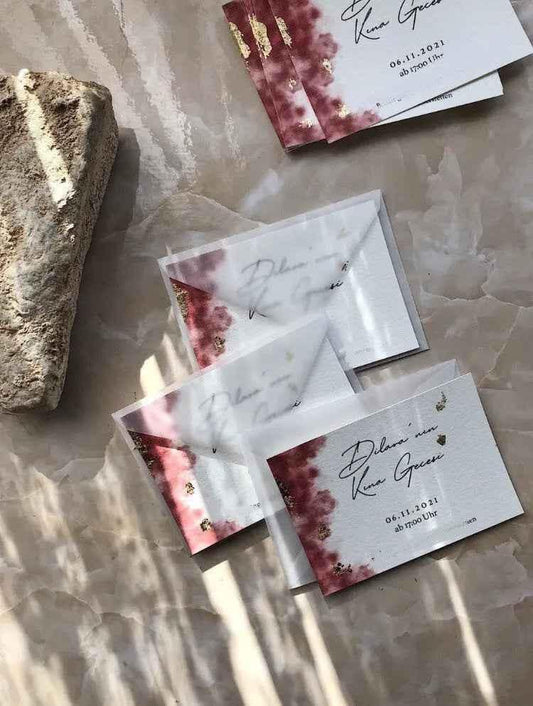 Karten mit goldenen Akzenten und rotem Aquarell-Design auf Marmoruntergrund, Hochzeitseinladungen