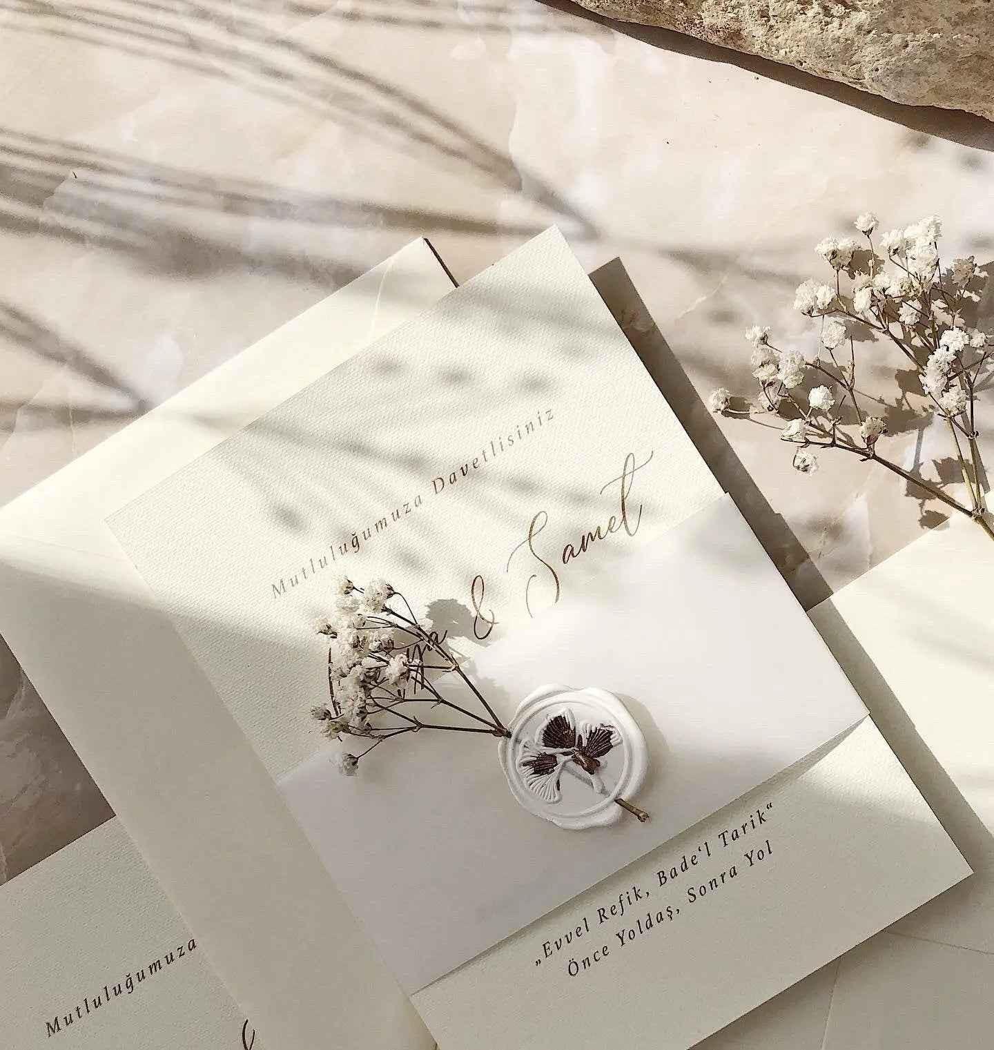 Vintage Hochzeitseinladung aus Creme-Papier mit Wachssiegel und Trockenblumen, elegant dekoriert