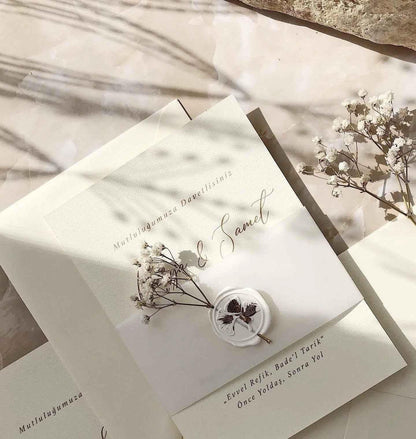 Vintage Hochzeitseinladung aus Creme-Papier mit Wachssiegel und Trockenblumen, elegant dekoriert